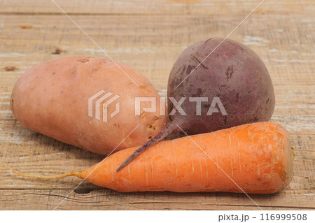 A Medley of Fresh Vegetables and Aromatic Garlic on a Rustic Wooden Background Surface A Medley of Fresh Vegetables and Aromatic Garlic on a Rustic Wooden Background Surface 116999508