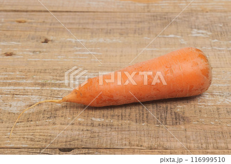 A Fresh Organic Carrot Placed Beautifully on a Rustic Wooden Surface for Presentation A Fresh Organic Carrot Placed Beautifully on a Rustic Wooden Surface for Presentation 116999510