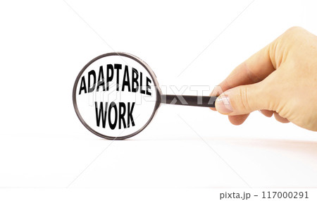 Adaptable work symbol. Concept words Adaptable work in beautiful magnifying glass. Beautiful white paper background. Businessman hand. Business Adaptable work concept. Copy space. Adaptable work symbol. Concept words Adaptable work in beautiful magnifying glass. Beautiful white paper background. Businessman hand. Business Adaptable work concept. Copy space. 117000291