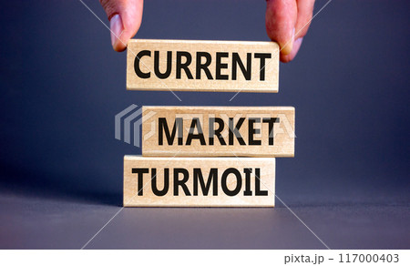 Current market turmoil symbol. Concept words Current market turmoil on wooden blocks on a beautiful grey table grey background. Businessman hand. Business, finacial current market turmoil concept. 117000403