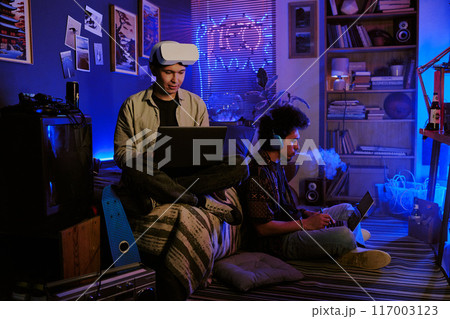 Gamers chilling together while having coop stream in neon room 117003123