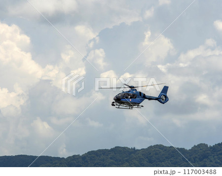 真夏の空を飛ぶ大阪府警察航空隊のヘリコプター 117003488