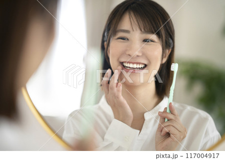 鏡を見ながら歯磨きをするアラサーの女性 117004917