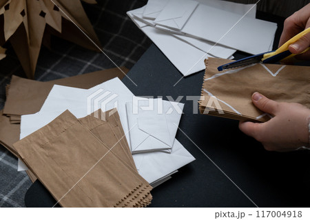 Master class of cutting making craft paper snowflakes for conscientious Christmas decor. Sustainable celebration minimal responsible DIY holiday project. Step by step 117004918