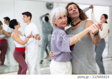 Caucasian man and mature woman learning paired latin dances 117005623