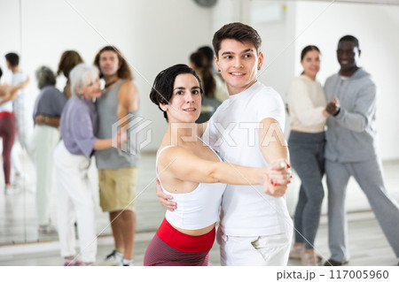 Guy learning to dance waltz with Hispanic girl in dancing class Guy learning to dance waltz with Hispanic girl in dancing class 117005960