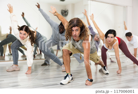Group of active people performing a stretching exercise Group of active people performing a stretching exercise 117006001