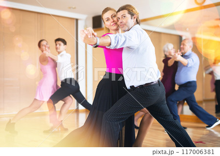 Adult couple enjoying slow foxtrot in dance studio Adult couple enjoying slow foxtrot in dance studio 117006381