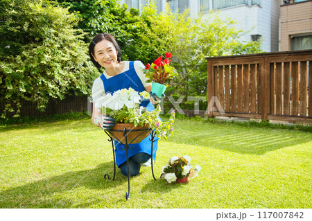 寄せ植えをする笑顔のミドル女性 117007842