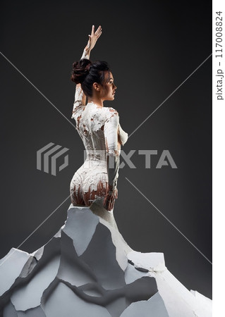 Woman Covered in White Clay Posing on White Rock Formation Woman Covered in White Clay Posing on White Rock Formation 117008824