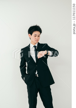 時計を見る20代ビジネスマン 117011150