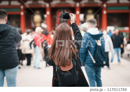 Tourist woman visit Sensoji Temple or Asakusa Kannon Temple is a Buddhist temple located in Asakusa, Tokyo Japan. Japanese sentence on red lantern means Thunder gate. 117011789