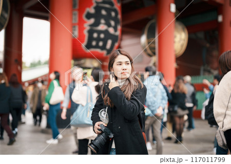 Tourist woman visit Sensoji Temple or Asakusa Kannon Temple is a Buddhist temple located in Asakusa, Tokyo Japan. Japanese sentence on red lantern means Thunder gate. 117011799