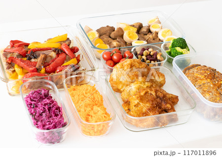 窓辺のテーブルに並んだガラスの保存容器に詰められた作り置き料理 117011896