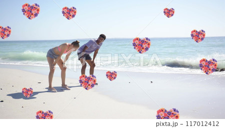 Image of hearts moving over diverse couple in love on beach in summer 117012412
