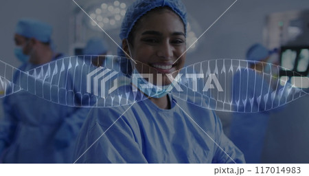 Image of dna strands and data processing over biracial female surgeon in hospital 117014983