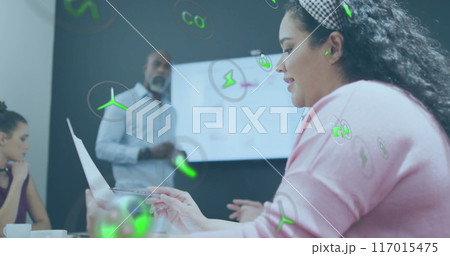 Image of ecology icons over diverse colleagues having meeting in office 117015475