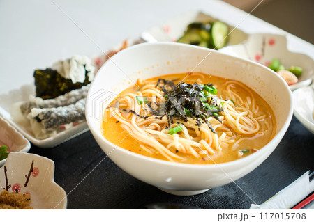 Steaming bowl of japanese ramen noodles being served with side dishes Steaming bowl of japanese ramen noodles being served with side dishes 117015708