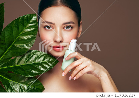 Close up woman face with green exotic leaf 117016217