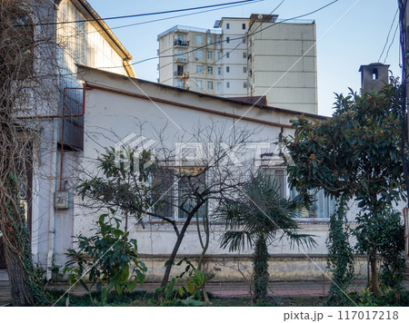 Backyard in the old area. Facade of an old house. Shabby walls of the house. 117017218
