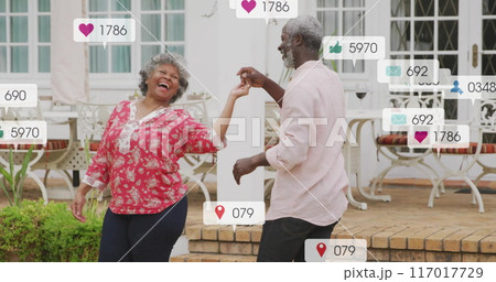 Dancing couple with social media notifications image over garden background 117017729