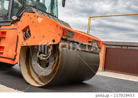 A skating rink compacts fresh asphalt in a cottage village 117019453