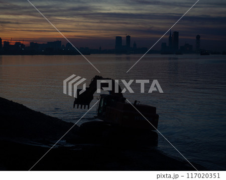 Excavator work at night. Overtime work. The work of construction equipment on the seashore. Batumi. Fortified shores. at sunset. Hitachi 117020351