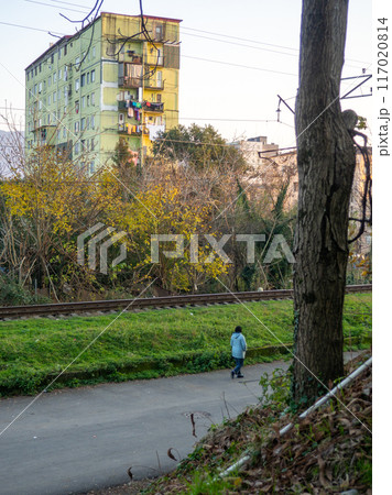 Man on the alley in the autumn park. The streets of the city. Winter landscape of the southern city. Outskirts of the city of Batumi. Man on the street. Winter at the resort. Man on the alley in the autumn park. The streets of the city. Winter landscape of the southern city. Outskirts of the city of Batumi. Man on the street. Winter at the resort. 117020814