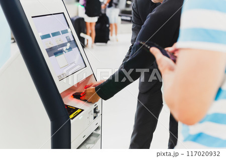 Male passenger doing self check in for flight at modern airport. 117020932
