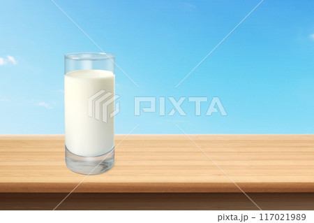 Glass of milk on wooden table with sky backdrop Glass of milk on wooden table with sky backdrop 117021989