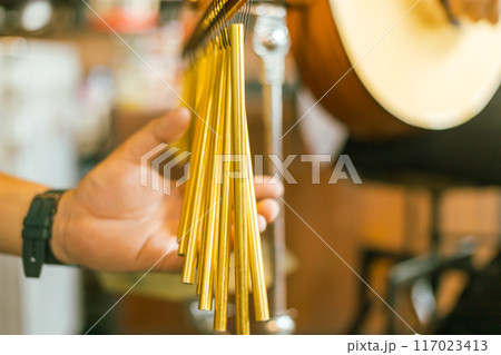 Close up hand of musician play bar chimes 117023413