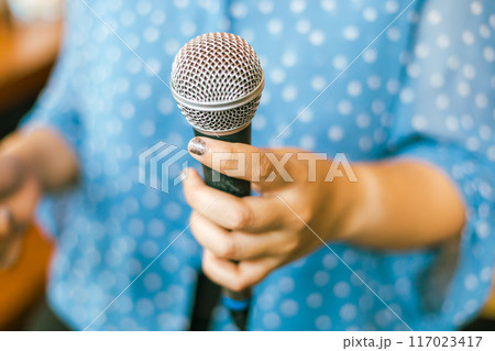 Close up hand holding a microphone Close up hand holding a microphone 117023417