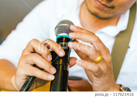 Close up hand holding a microphone 117023418