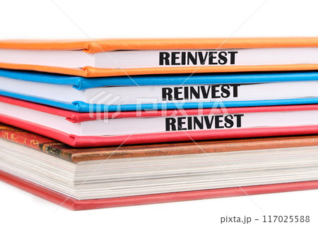 Business and reinvest concept. Copy space. REINVEST word on the ends of notebooks lying on top of each other on a white background Business and reinvest concept. Copy space. REINVEST word on the ends of notebooks lying on top of each other on a white background 117025588