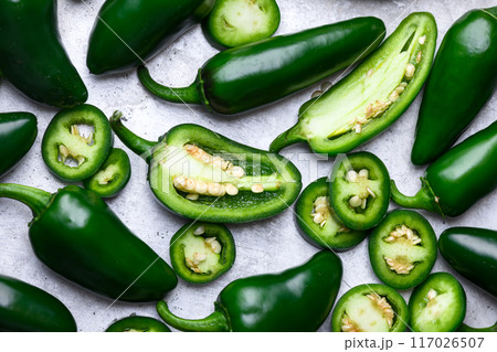 Whole, half and sliced green jalapeno hot peppers on metal sheet 117026507