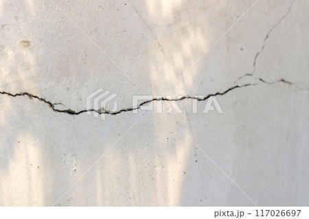 Cracked concrete wall covered with a gray cement surface as a background Cracked concrete wall covered with a gray cement surface as a background 117026697
