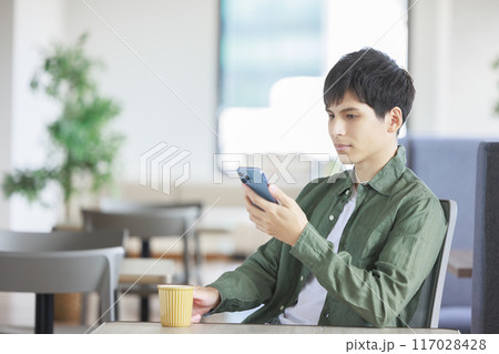 カフェでスマホを操作する男性 117028428