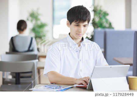 カフェで仕事をする男性 117028449
