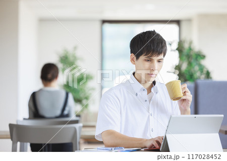 カフェで仕事をする男性 117028452