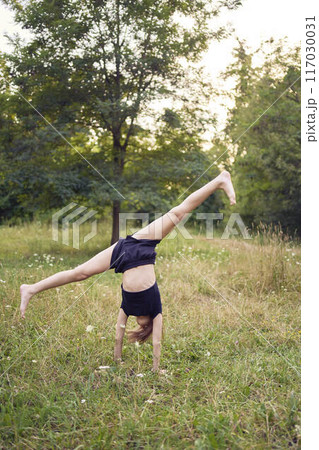 A 10-year-old gymnast practices in the garden A 10-year-old gymnast practices in the garden 117030031