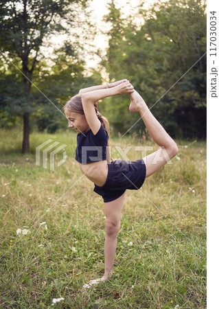A 10-year-old gymnast practices in the garden A 10-year-old gymnast practices in the garden 117030034