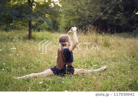 A 10-year-old gymnast practices in the garden A 10-year-old gymnast practices in the garden 117030042