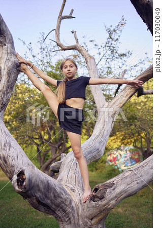 A 10-year-old gymnast practices in the garden 117030049