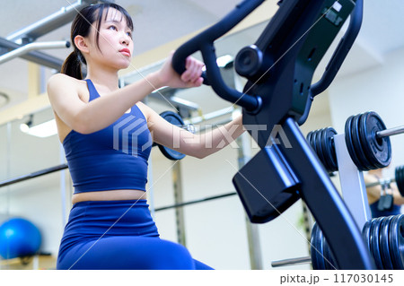 ジムで体を鍛える女性　エアロバイク　フィットネスバイク　筋トレ女子　ダイエット 117030145