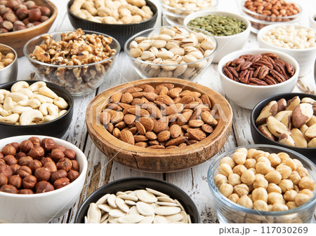 Mixed raw nuts and seeds in bowls on kitchen table.Peanut,hazelnut,walnut,almonds,pistachio Mixed raw nuts and seeds in bowls on kitchen table.Peanut,hazelnut,walnut,almonds,pistachio 117030269