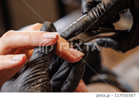 Manicurist doing hardware manicure to female client using special tools 117030367