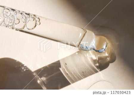 Pipette with serum on a beige background. 117030423
