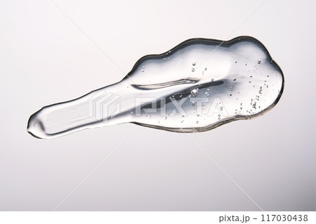 A smear of cosmetic gel close-up on a gray background. Appetizing texture with bubbles. 117030438