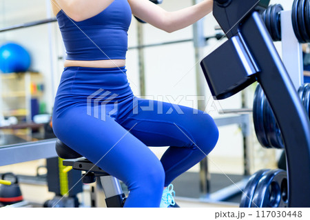 ジムで体を鍛える女性　エアロバイク　フィットネスバイク　筋トレ女子　ダイエット　下半身　顔無し 117030448