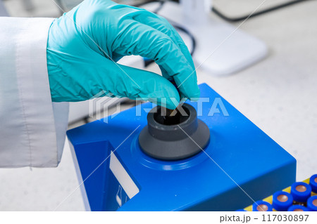 Prior to HPLC analysis, a chemist shakes samples using a vortex mixer 117030897